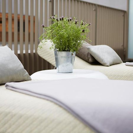 Steigenberger Hotel Am Kanzleramt Berlin Room photo The photo shows two lounge chairs with soft, light-colored cushions. Between them, there is a small round table featuring a metal bucket filled with greenery. The setting appears to be designed for relaxation, with a clean and modern aesthetic, likel