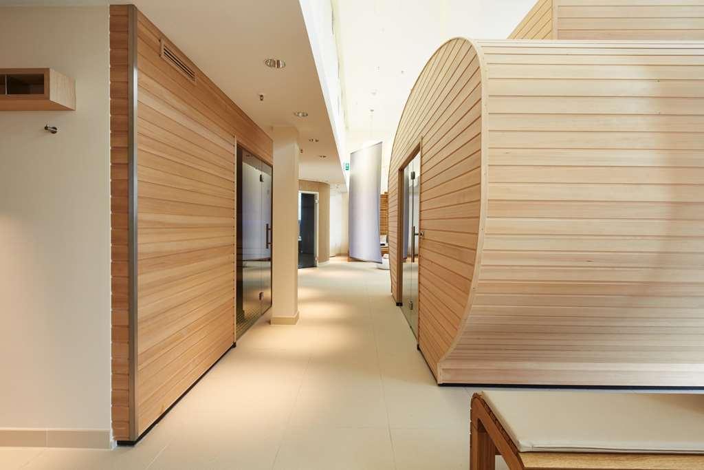 Steigenberger Hotel Am Kanzleramt Berlin Facilities photo The photo shows a modern interior space, likely a wellness or spa facility. It features a corridor lined with wooden paneling, giving a warm and natural feel. On either side of the corridor, there are rounded and rectangular wooden structures, possib